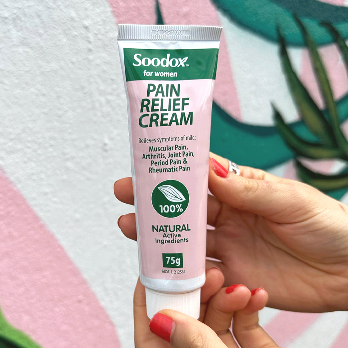Hand holding Soodox for Women Pain Relief Cream 75g tube