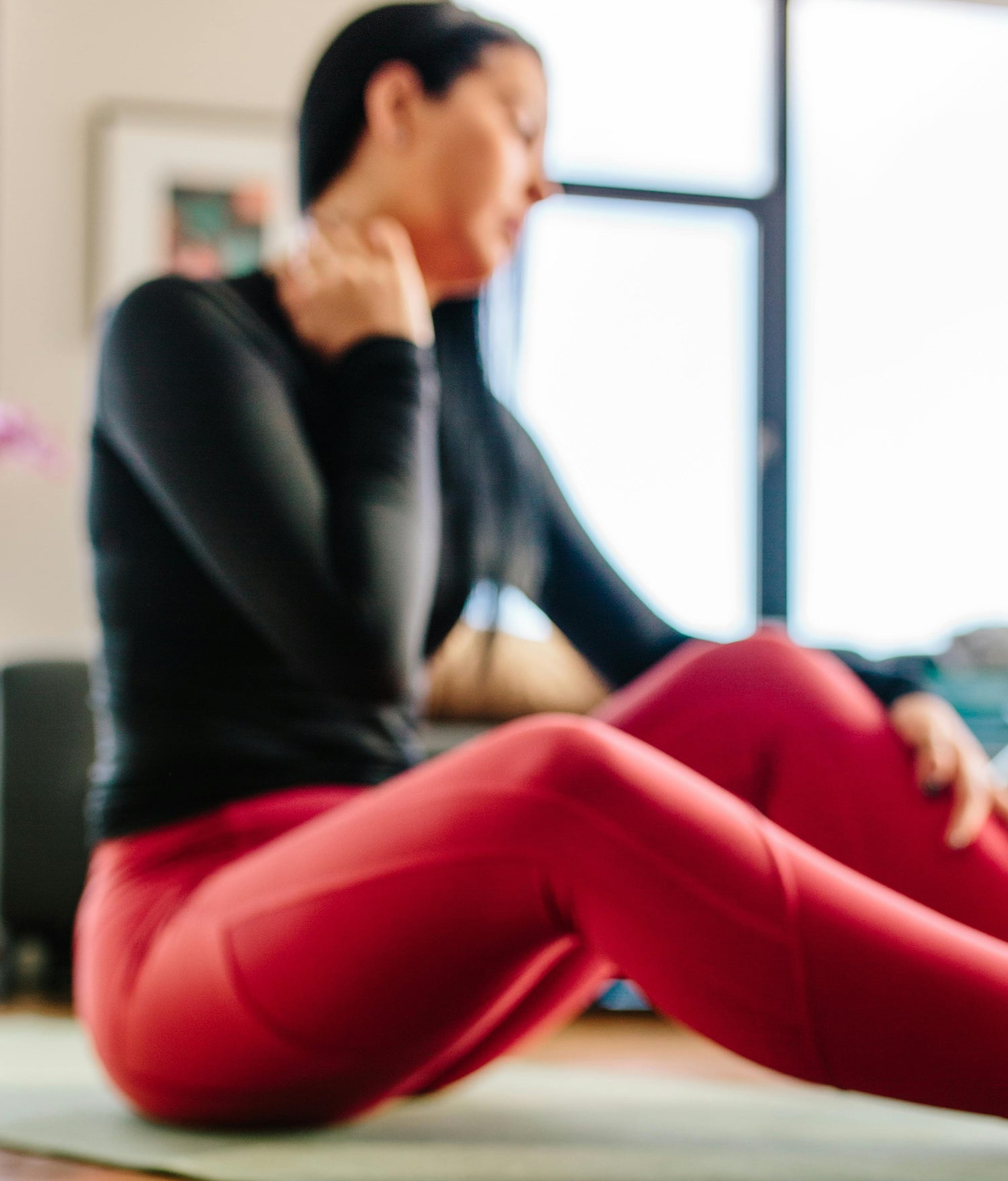 A woman doing exercise with a neck strain and in pain