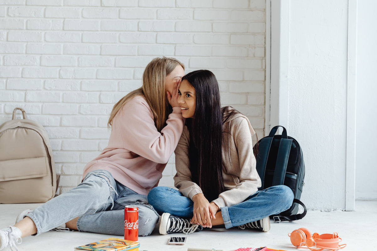 Two friends sitting together and sharing a quiet conversation