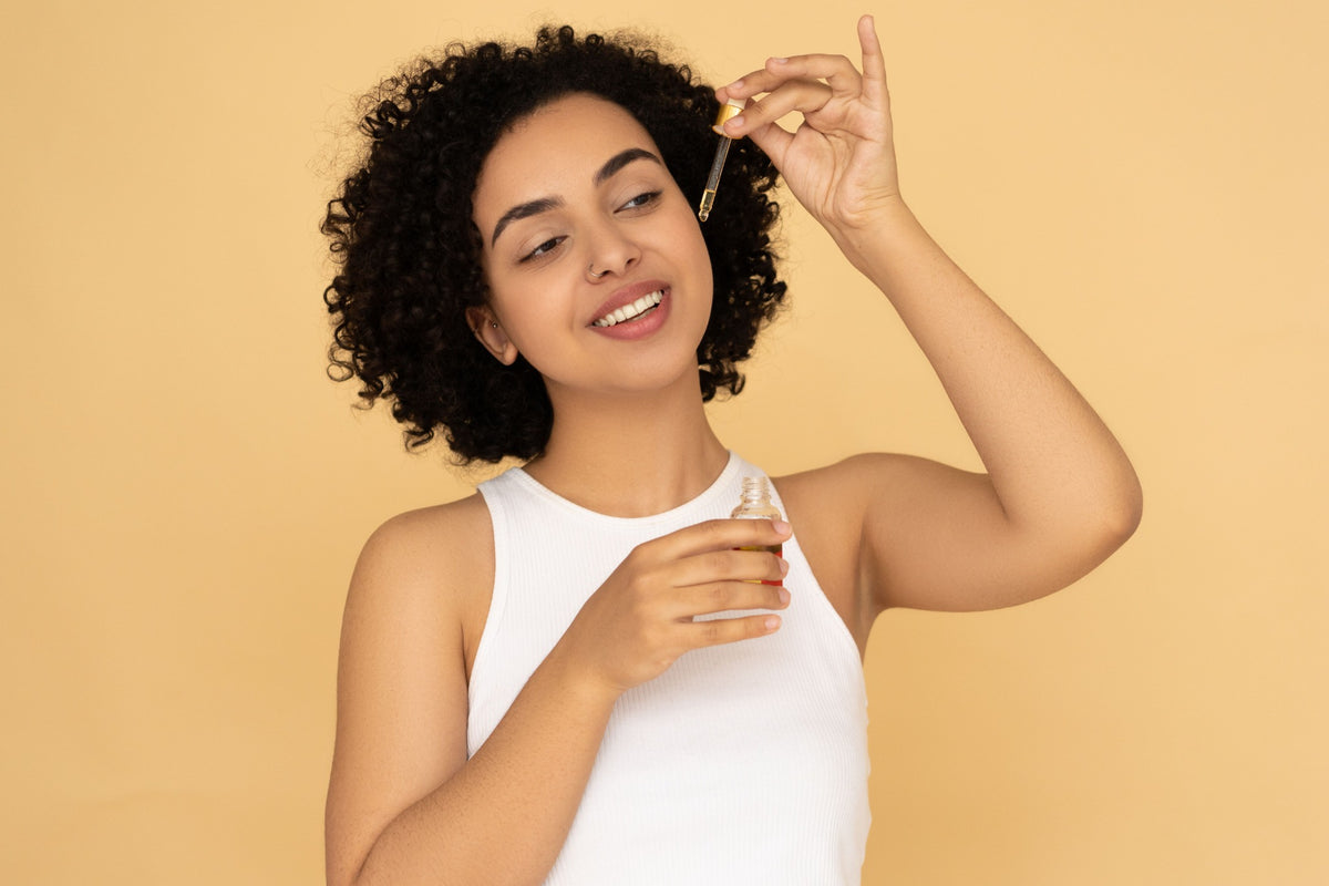 Woman holding an oil bottle and dropper