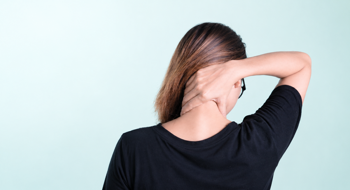 Woman holding her neck, with light space on the left