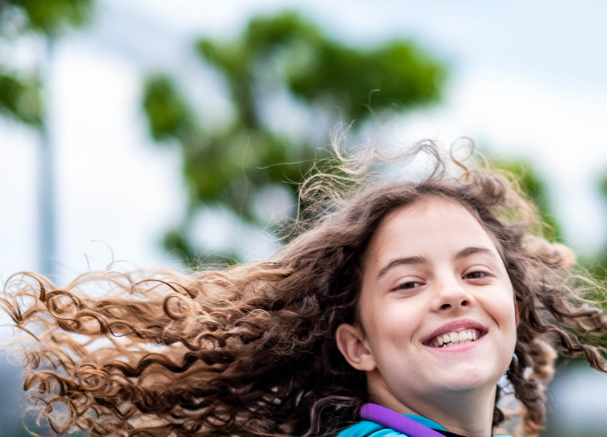 Girl outdoors with flowing hair and headphones